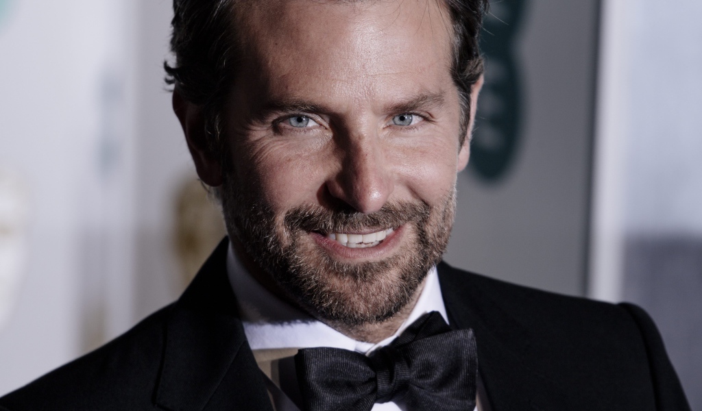 Улыбающийся актер Брэдли Купер в костюме