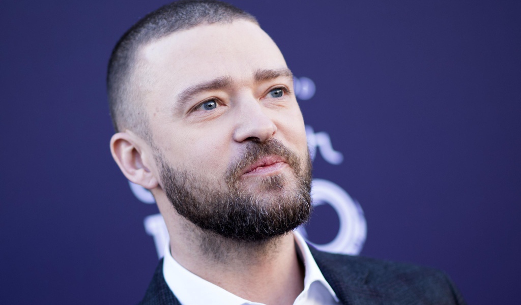 Лицо голубоглазого актера Джастина Тимберлейка на синем фоне