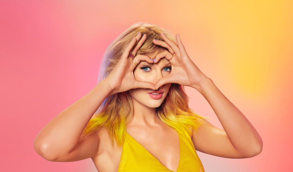 Красивая певица Тейлор Свифт делает сердце из рук на лице