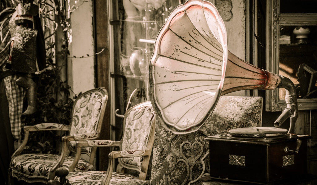 Большой старый граммофон в комнате со стульями