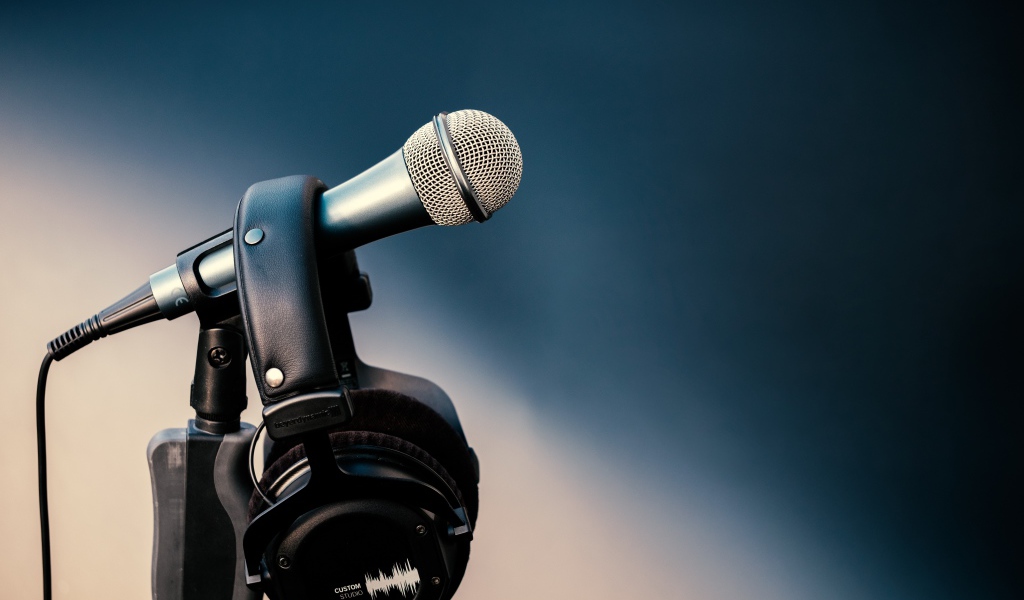 Микрофон с черными наушниками на стойке 