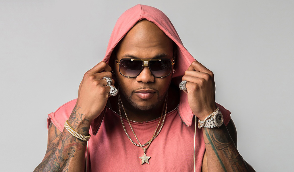 Рэпер Flo Rida на сером фоне