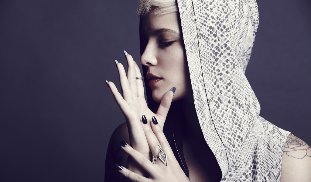 Певица Холзи в капюшоне на сером фоне