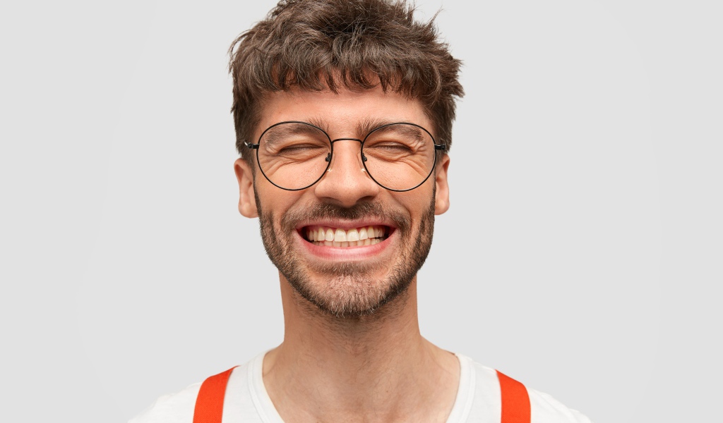 Улыбающийся бородатый мужчина в очках 