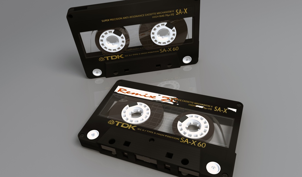 Две магнитофонные кассеты TDK на сером фоне