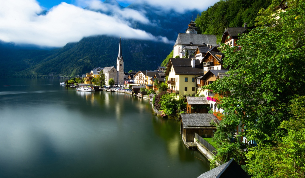 Красивые дома на берегу спокойного озера у подножия гор 