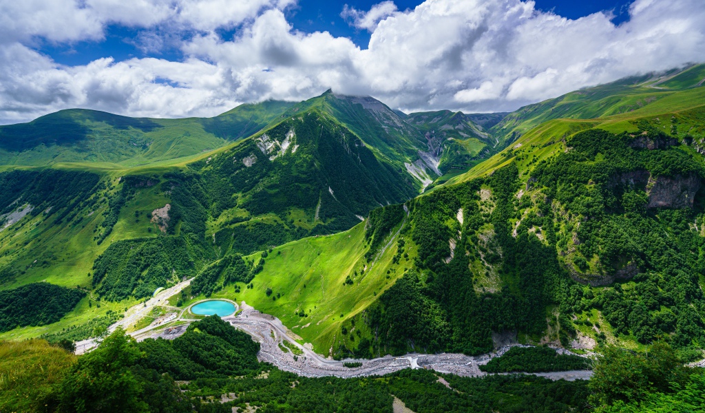 Красивые живописные зеленые  холмы под голубым небом с белыми облаками