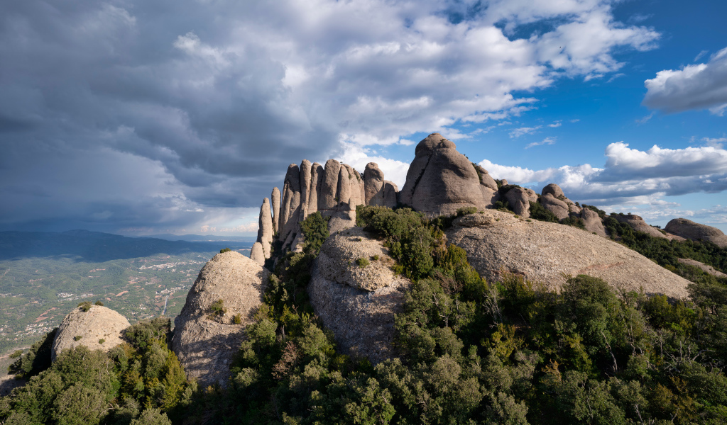 Каменные глыбы под голубым небом с грозовыми облаками 