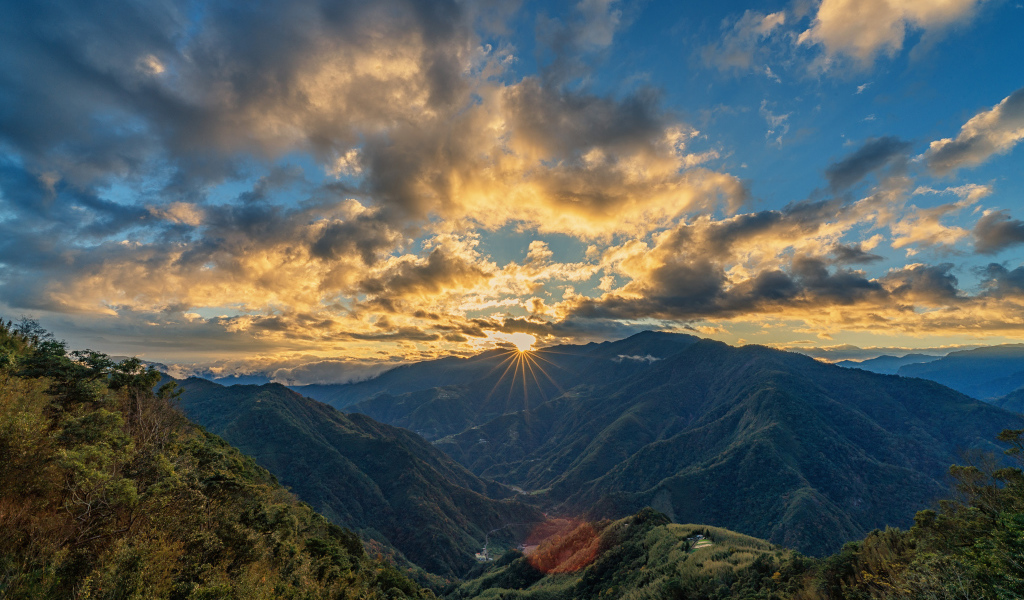 Рассвет солнца в облачном небе над горами 