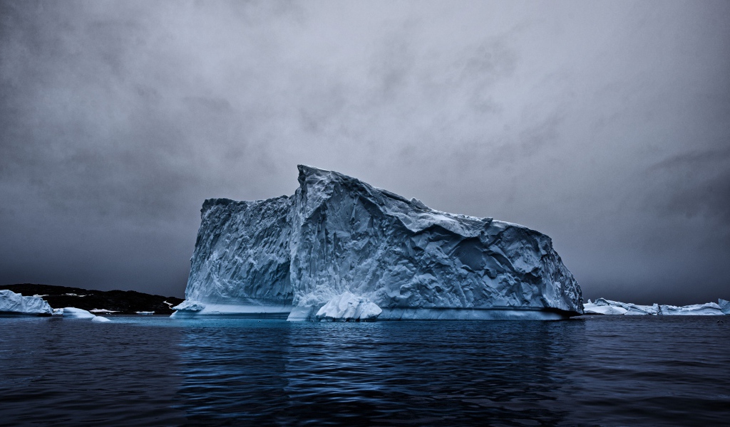 Большой айсберг в океане под пасмурным небом