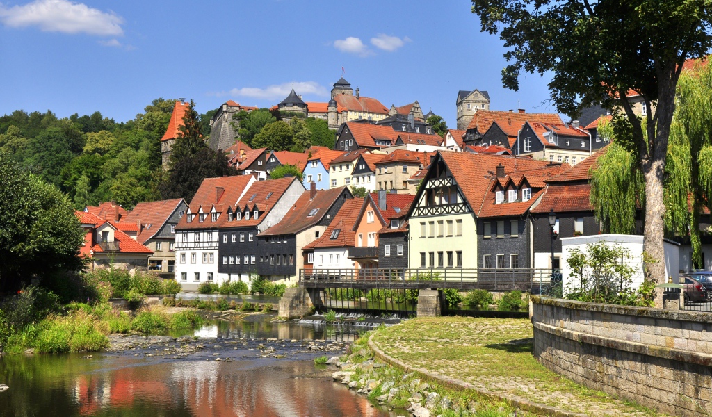 Много домов у пруда на фоне голубого неба