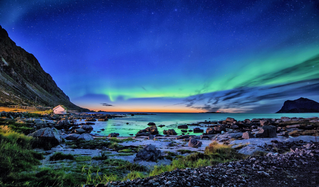 Северное сияние в небе над горным озером