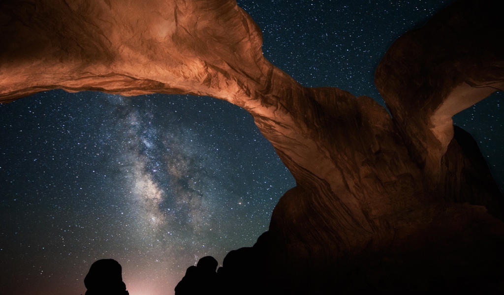 Каменная природная арка под звездным небом ночью 