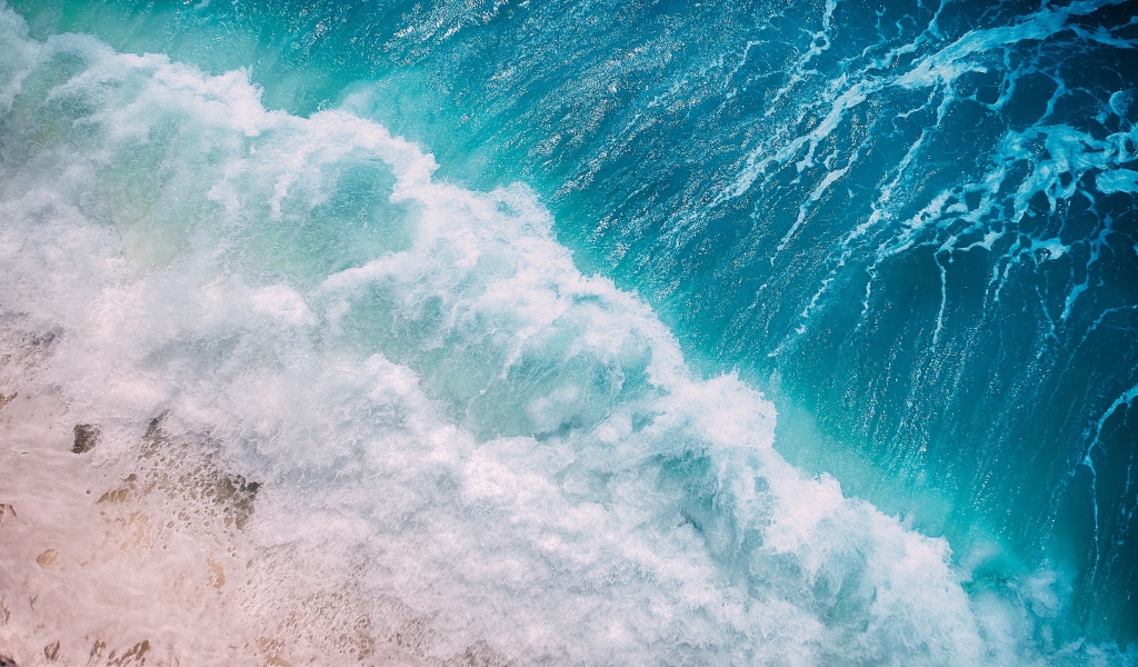 Бурные белые волны океана на песке 