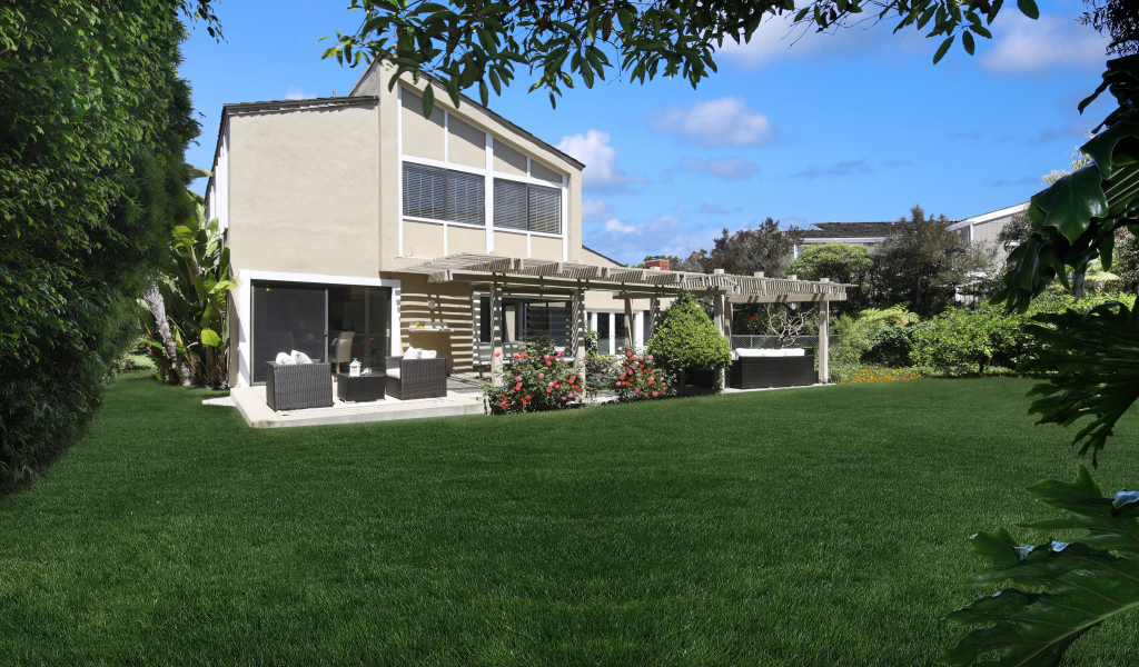 Двухэтажный дом с зеленым газоном 