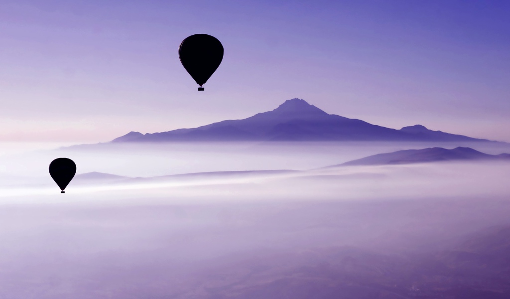 Два воздушных шара в небе над облаками