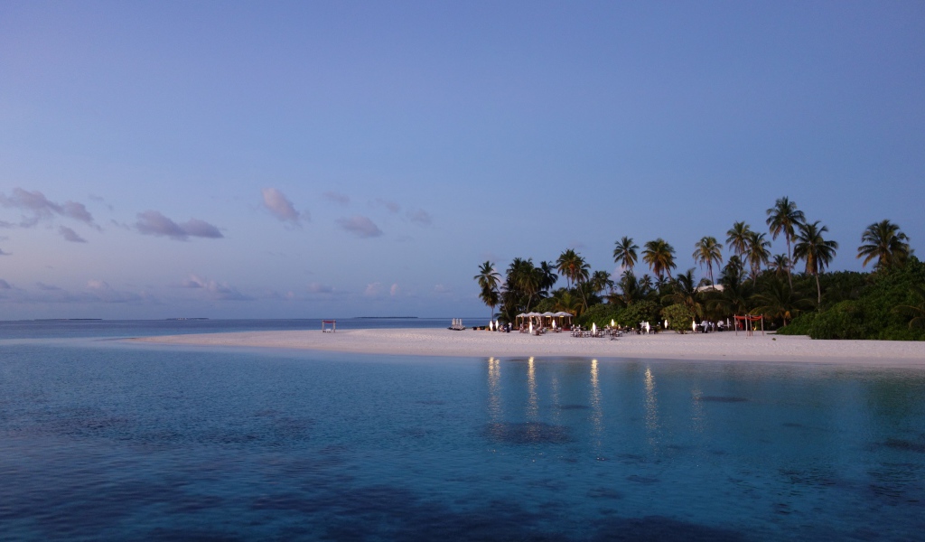 Calm blue ocean water on a tropical beach at dusk