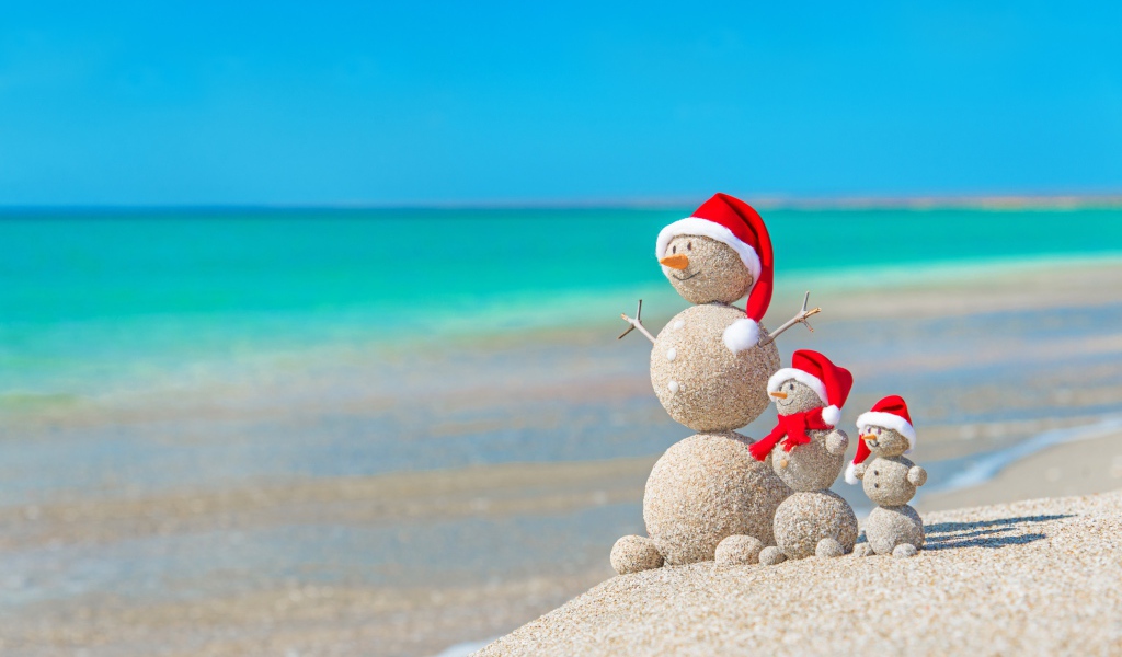 Снеговики из песка на берегу океана 