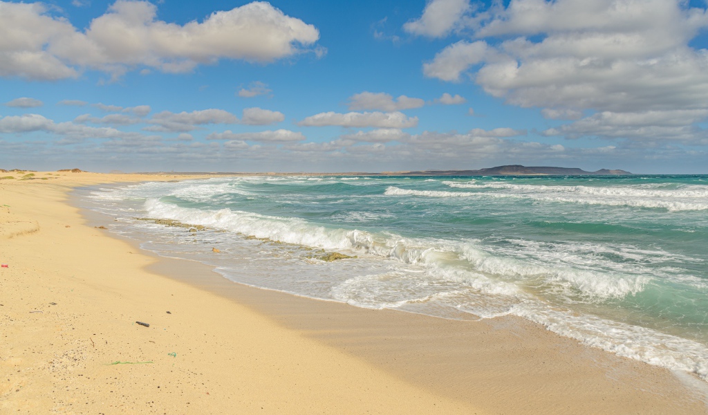 Бушующие морские волны на желтом горячем песке 