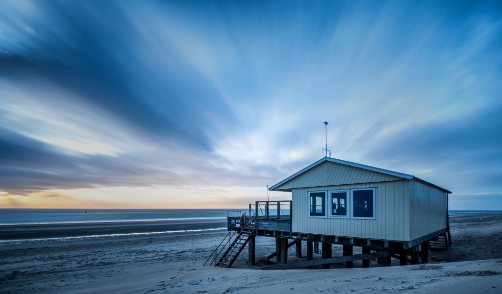 Дом спасателей стоит на пляже под красивым небом