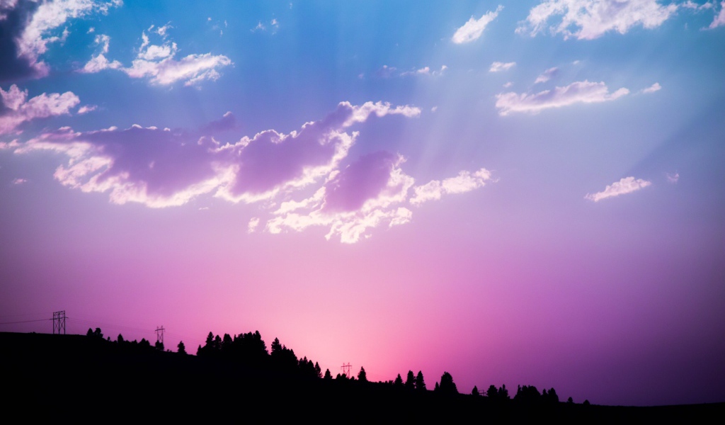 Красивое сиреневое небо с яркими лучами солнца
