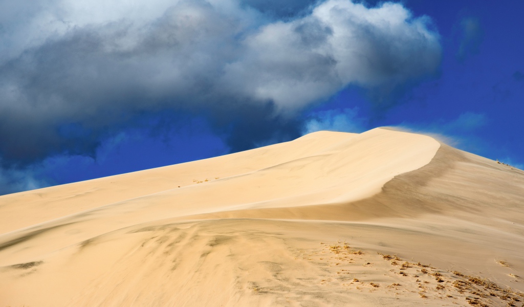 Песчаный бархан под голубым небом