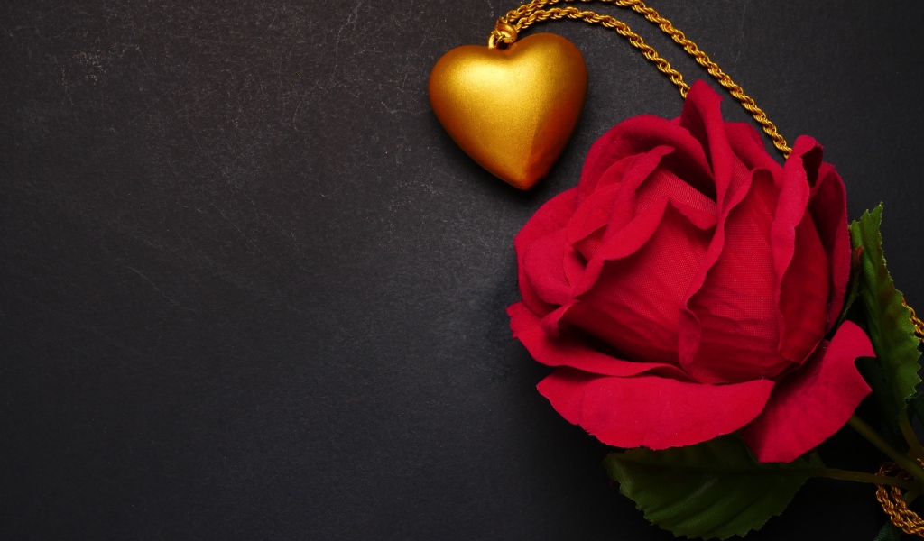 Искусственная красная роза с кулоном на сером фоне