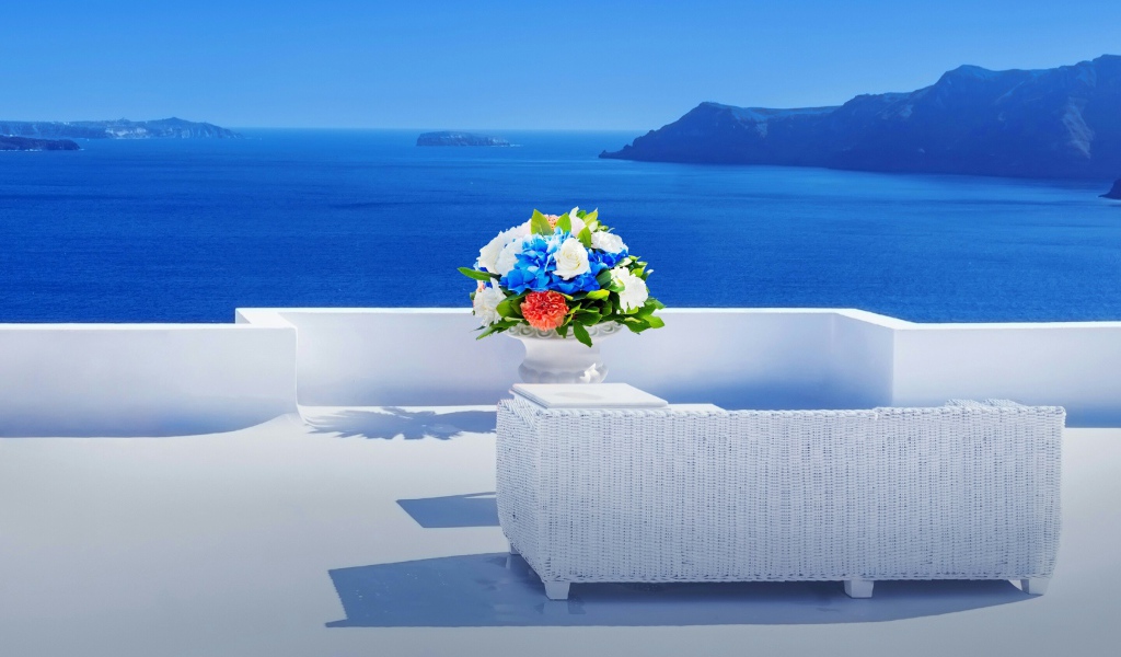 Красивый букет цветов на белом столе на фоне моря