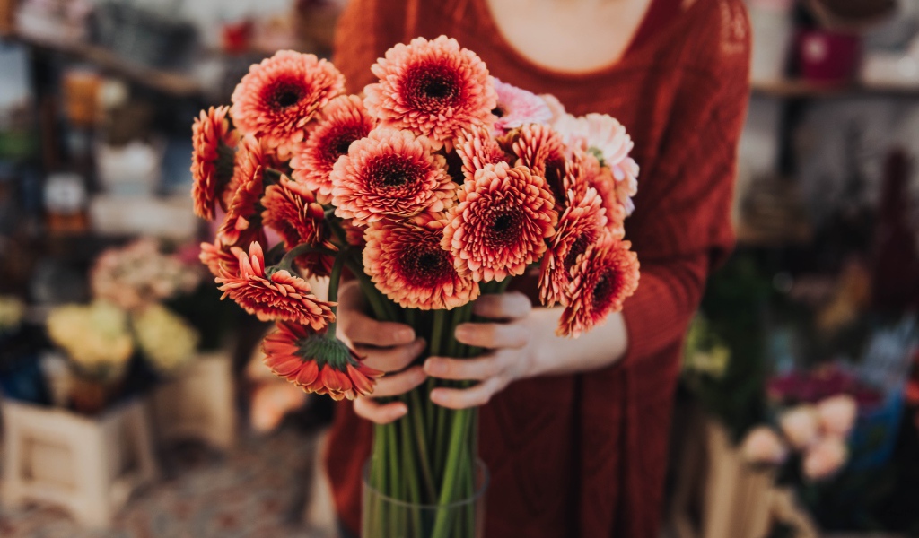 Красивый букет оранжевых гербер в руках у женщины 