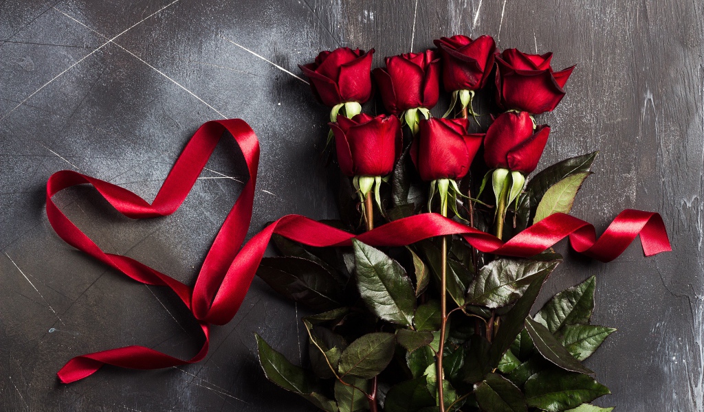 Букет красивых английских роз с красной лентой на сером фоне