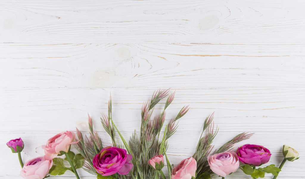 Букет разноцветных лютиков на белом столе