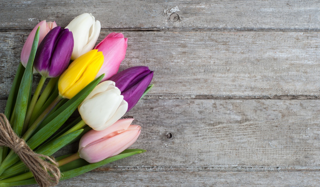 Букет разноцветных тюльпанов на деревянном столе