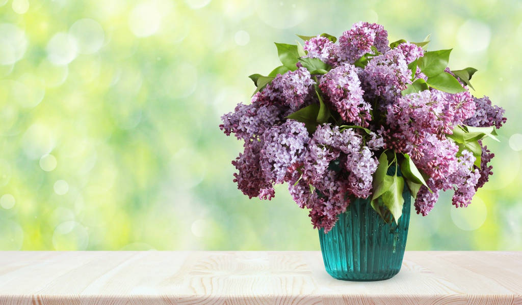 Букет ароматной сирени в вазе на столе