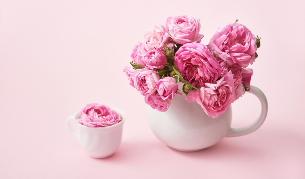 Букет розовых роз в белом кувшине на столе