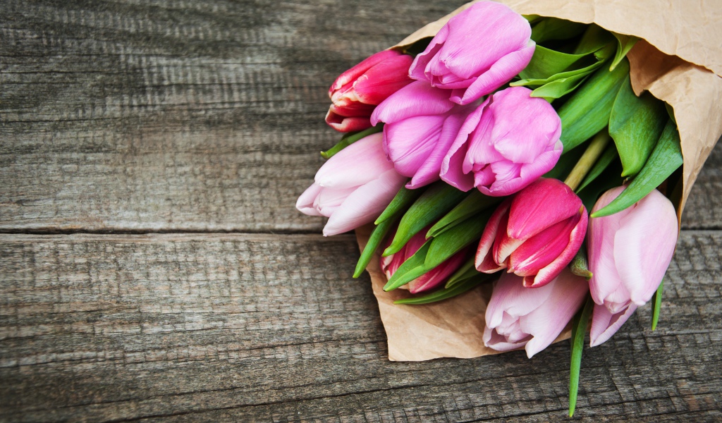 Букет розовых тюльпанов на деревянном столе 