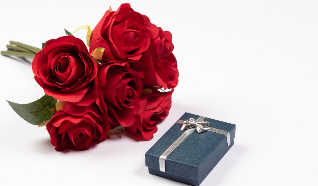 Букет красных искусственных роз с подарком на белом фоне