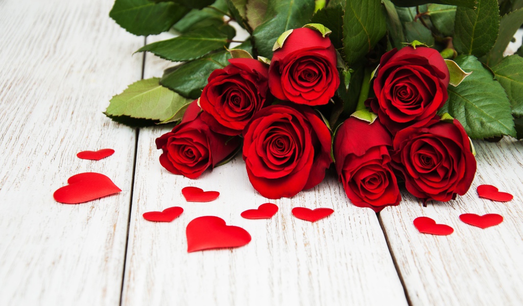 Букет красных роз с зелеными листьями на белом фоне с сердечками 