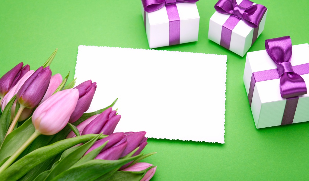Букет тюльпанов на столе с листом бумаги и подарками 