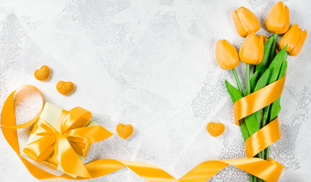 Букет желтых тюльпанов с лентой и подарком на сером фоне