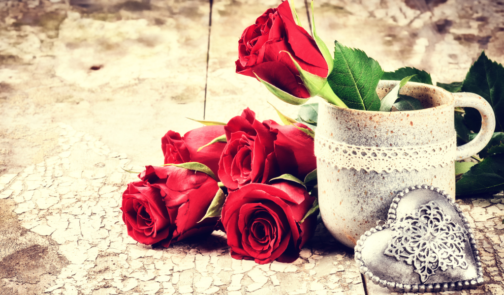 Красные розы на столе с кружкой и сердцем 
