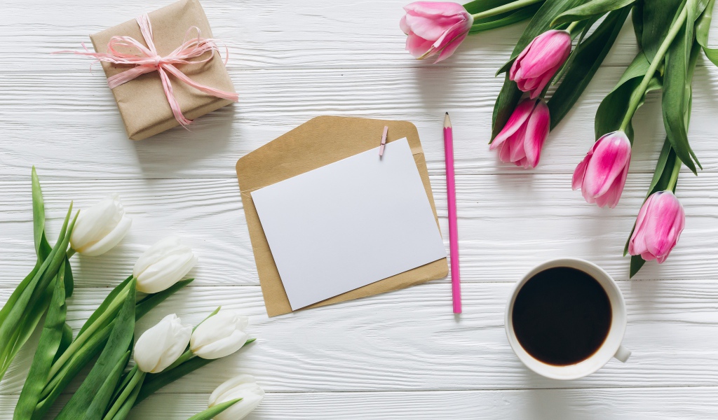Два букета тюльпанов на столе с подарком, кофе и письмом