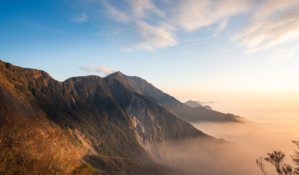 Красивый вид на покрытые туманом горы под голубым небом