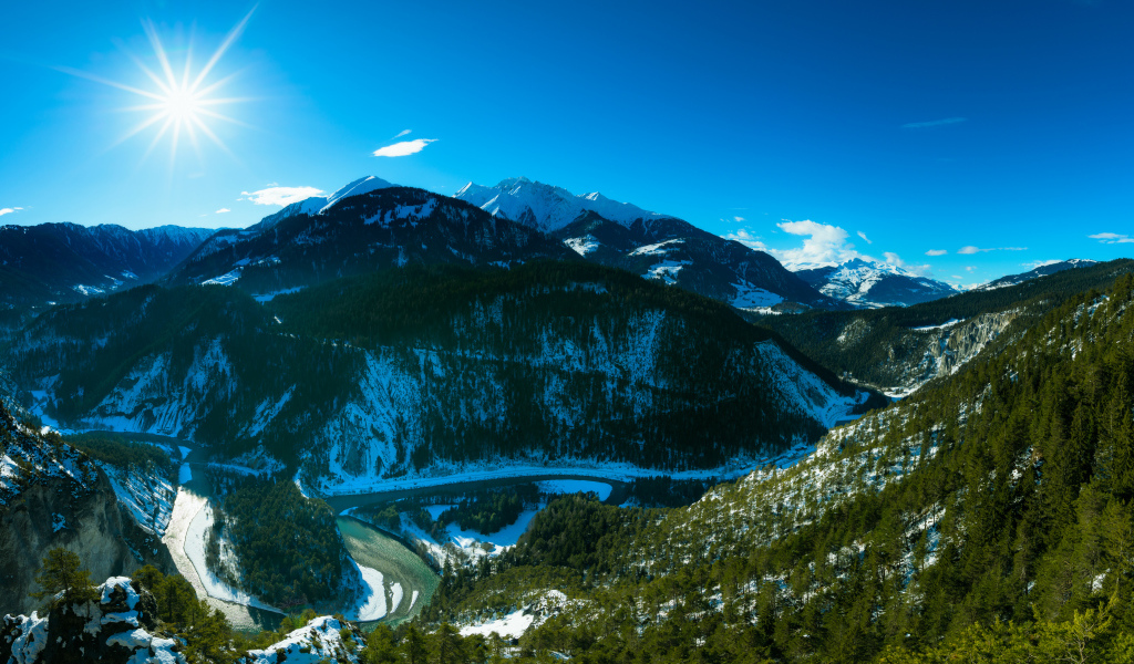 Яркое солнце в голубом небе над заснеженными горами, Швейцария 