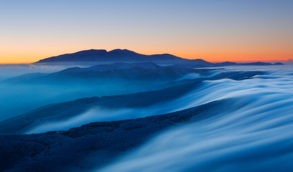 Туман покрывает высокие горы на рассвете 