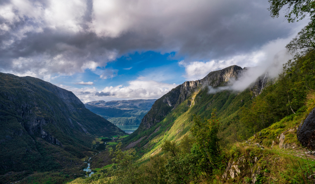 Покрытые зеленой растительностью горы под белыми облаками, Норвегия