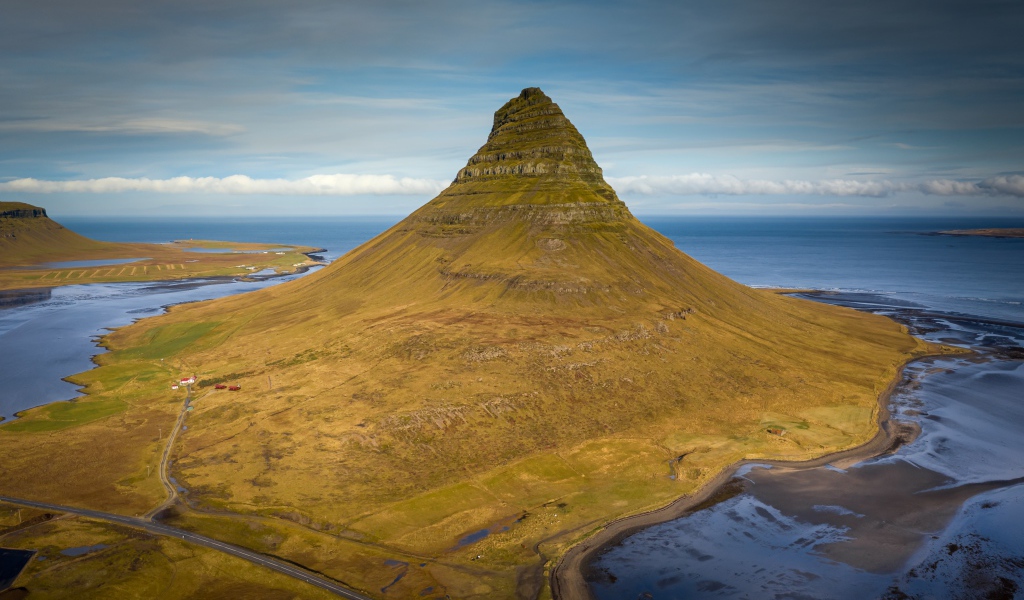 Зеленая гора Киркьюфетль под голубым небом, Исландия