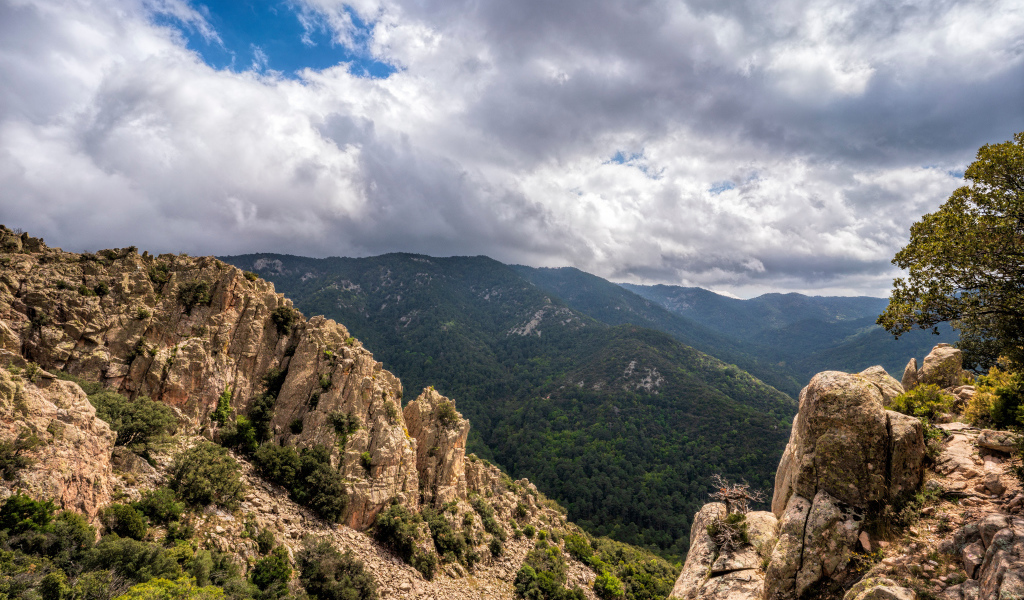 Зеленые вершины гор под белыми облаками 