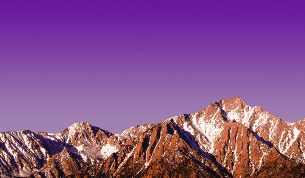 Вершины заснеженных гор на фоне сиреневого заката