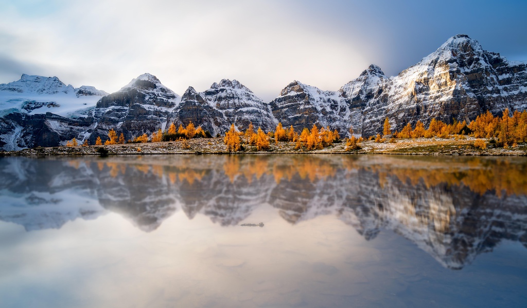 Заснеженные горы отражаются в воде озера 