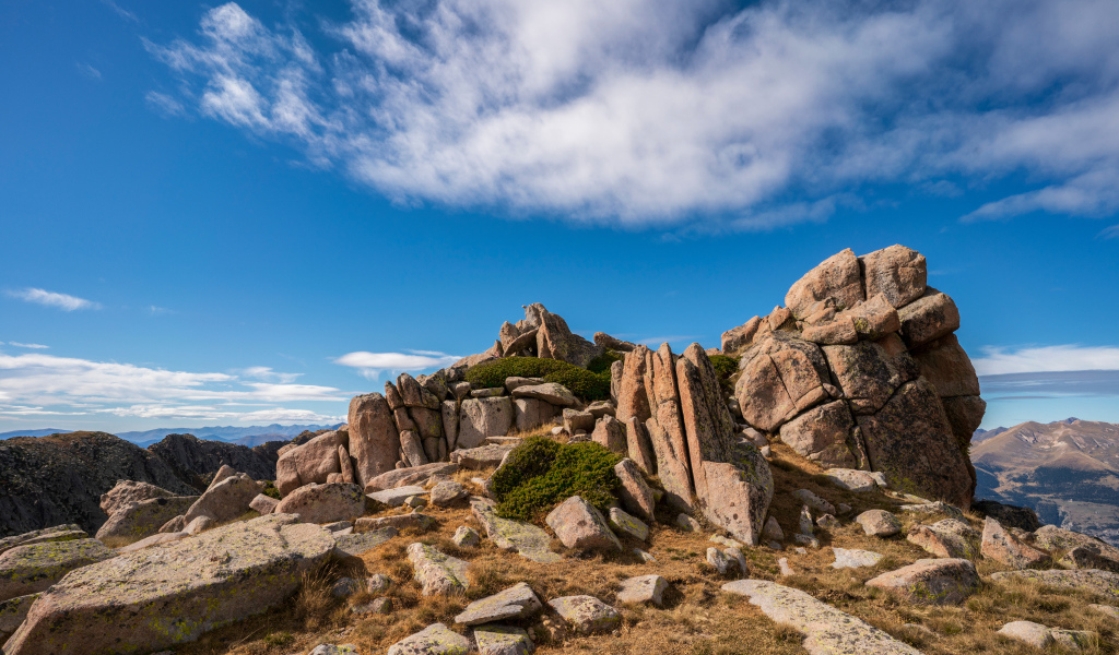 Каменные горы под голубым небом с белыми облаками 
